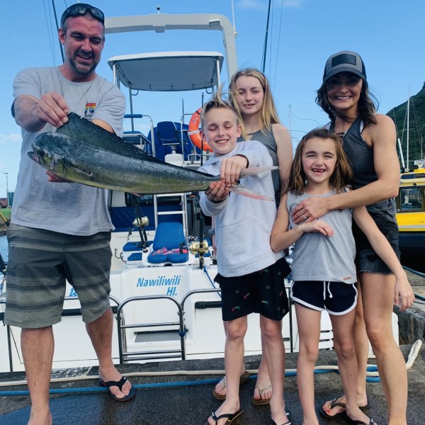 a person holding a fish on a boat posing for the camera