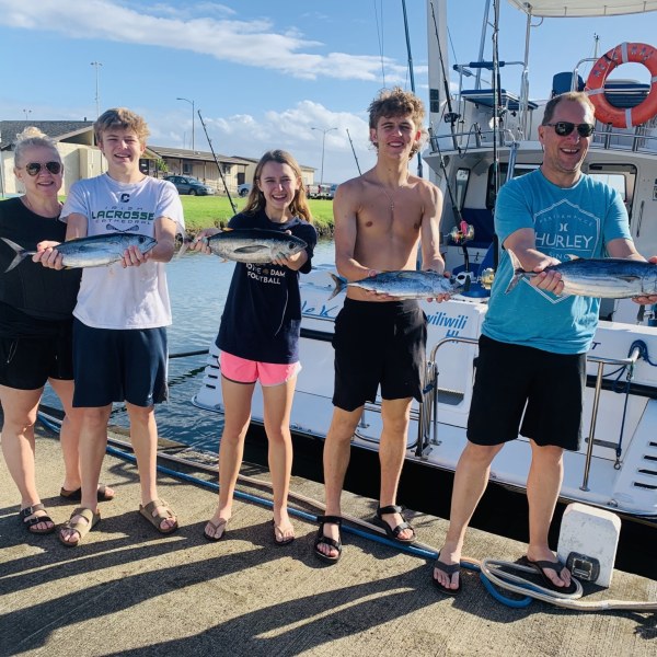 a group of people standing on a beach posing for the camera