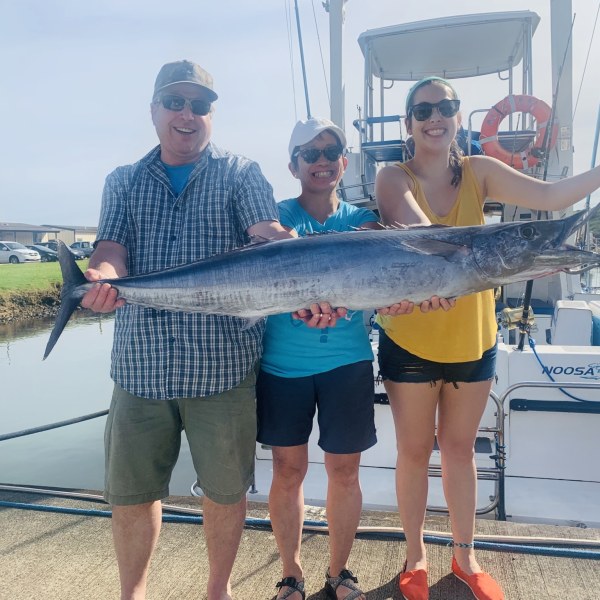 a person holding a fish on a boat