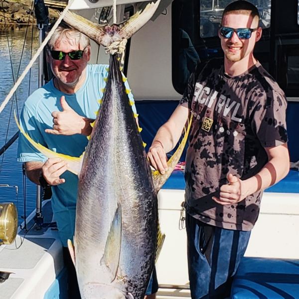 a man holding a fish on a boat
