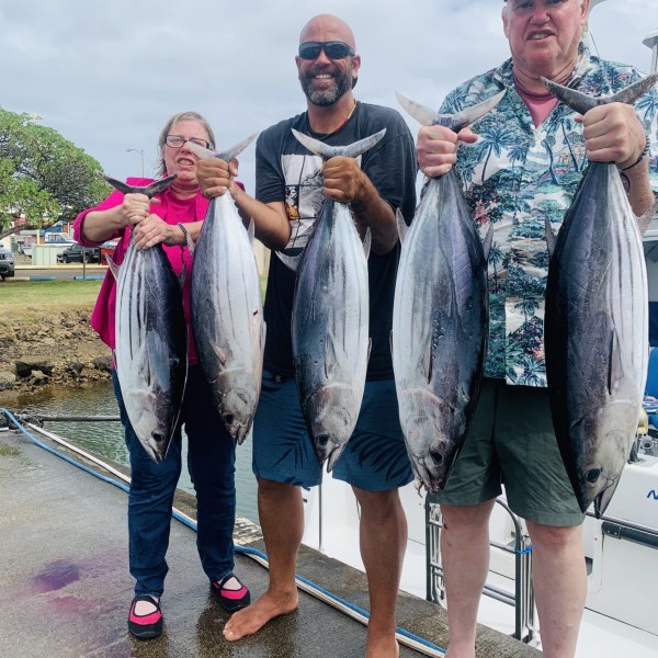 a group of people standing next to a person holding a fish