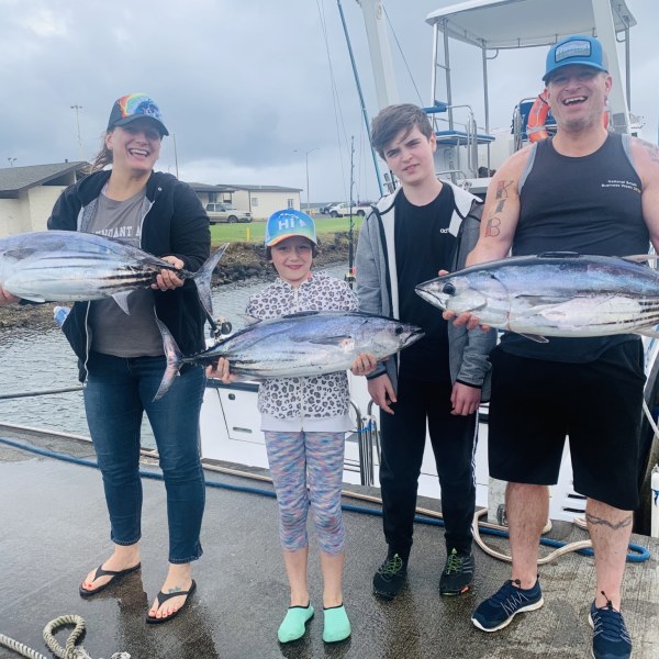 Skylar Gaertner et al. standing next to a person holding a fish
