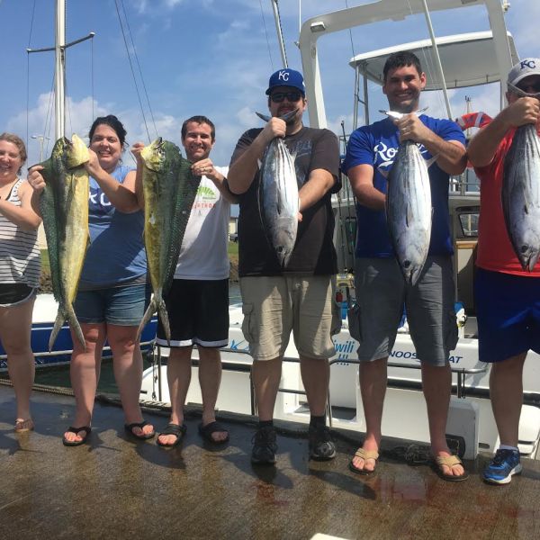 a group of people standing in front of a fish
