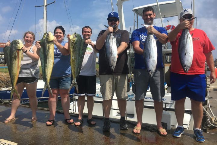 a group of people standing in front of a fish
