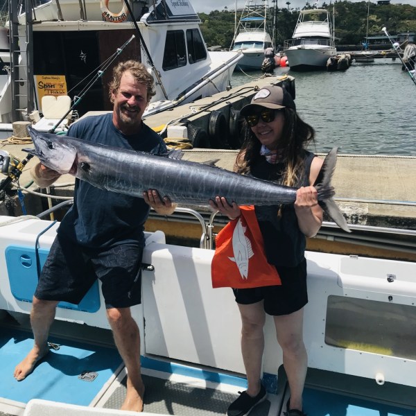 a person holding a fish on a boat