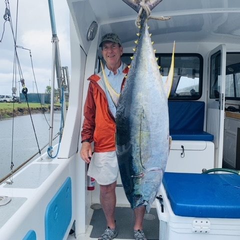 a man holding a fish on a boat
