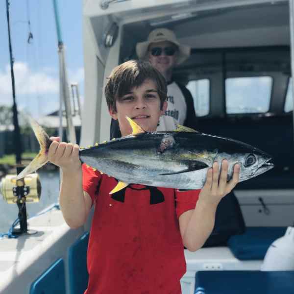 a man holding a fish on a boat