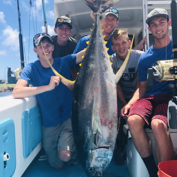 a person holding a fish on a boat posing for the camera