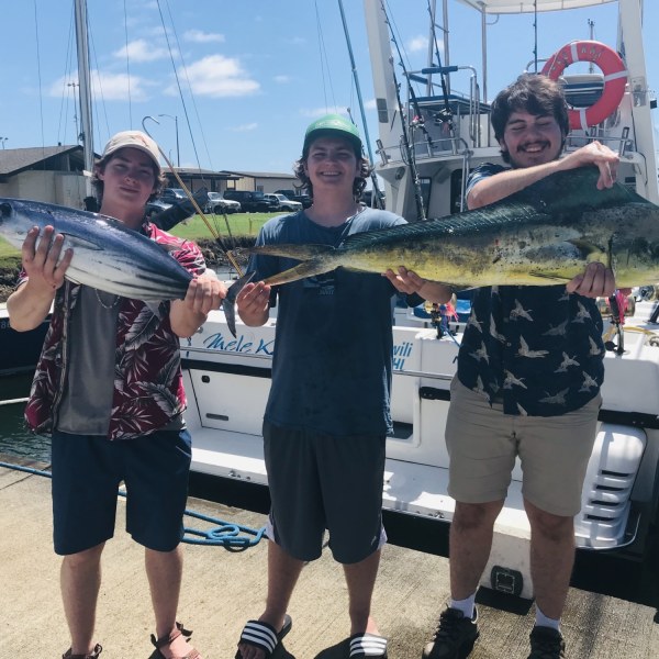 a group of people standing next to a person holding a fish