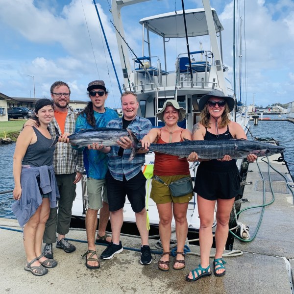 a group of people standing on a boat posing for the camera
