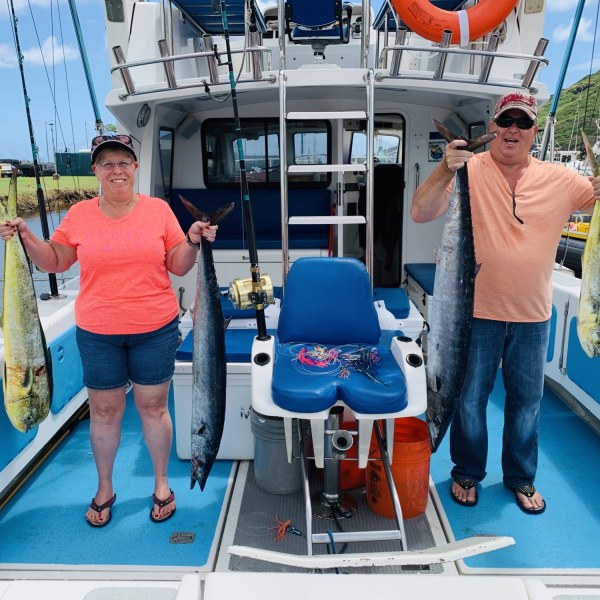 a man and a woman standing in front of a boat