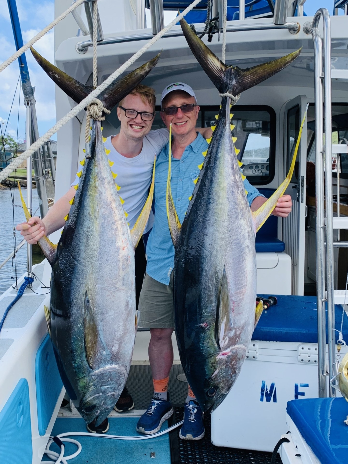 a person holding a fish on a boat posing for the camera