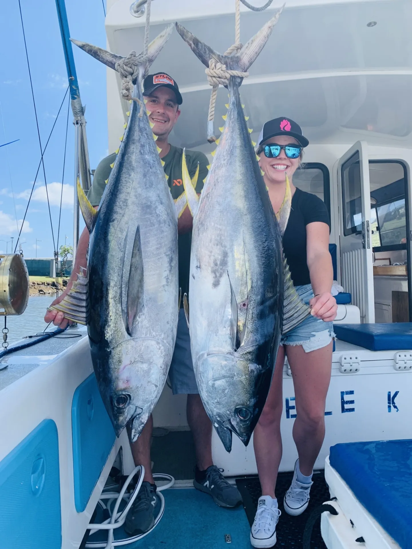 a person holding a fish on a boat posing for the camera