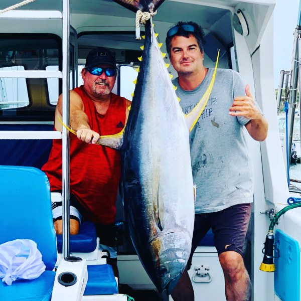 a man holding a fish on a boat
